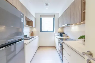a kitchen with white appliances and a window at Branded 2BR Residence with Direct Park Access in Dubai