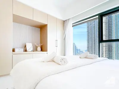 a bedroom with a large white bed with a large window at Luxurious Living in 2B with Burj & Fountain Views in Dubai