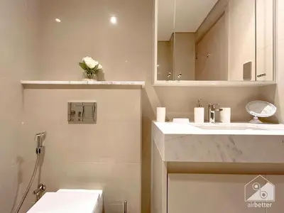 a bathroom with a sink and a toilet and a mirror at Luxurious Living in 2B with Burj & Fountain Views in Dubai