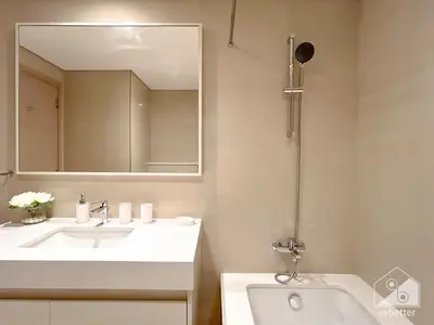 a white bathroom with a sink and a mirror at Luxurious Living in 2B with Burj & Fountain Views in Dubai