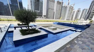 a fountain with a tree in the middle of a city at Charming 1BR Apartment in Vera Tower, Business Bay by Deluxe Holiday Homes in Dubai