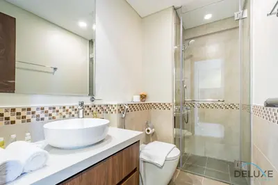 a bathroom with a sink and a glass shower at Charming 1BR Apartment in Vera Tower, Business Bay by Deluxe Holiday Homes in Dubai