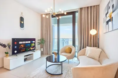 a living room with a couch and a tv at Beachfront 1BR Retreat at Address JBR in Dubai