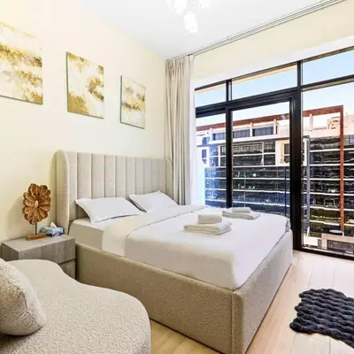 two beds in a room with a large window at Azizi Riviera 16 studio with Kitchenet - Ideal for monthly in Dubai