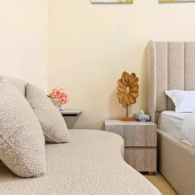 a bedroom with a couch and a bed and a table at Azizi Riviera 16 studio with Kitchenet - Ideal for monthly in Dubai