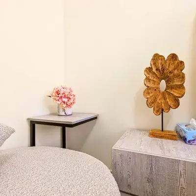 a room with a table and a table with a flower on it at Azizi Riviera 16 studio with Kitchenet - Ideal for monthly in Dubai