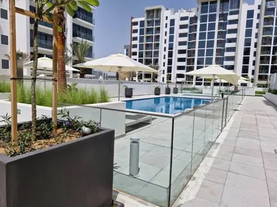 a swimming pool with umbrellas in a city at Azizi Riviera 16 studio with Kitchenet - Ideal for monthly in Dubai