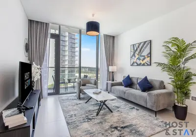 a living room with a couch and a table at 1 Bedroom - Crystal Lagoon - MBR City Meydan in Dubai