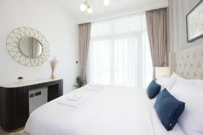 a white bedroom with a large bed and a window at Incredible Sea view 2BHK - Private beach Access - Emaar Beachfront in Dubai