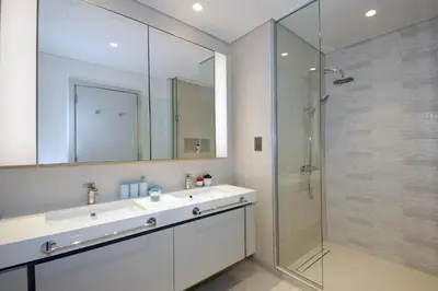 a bathroom with a sink and a glass shower at Incredible Sea view 2BHK - Private beach Access - Emaar Beachfront in Dubai