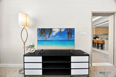 a living room with a tv on top of a dresser at Breathtaking 1BR in Palm Tower, with Sea View in Dubai