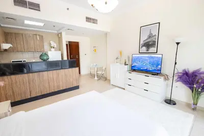 a living room with a television and a kitchen at Dubai Downtown Dubai Mall & Burj Khalifa DIFC 5 mins in Dubai