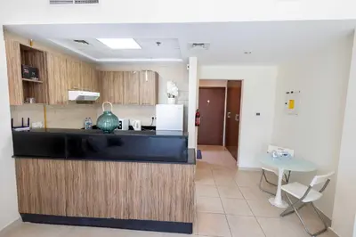 a kitchen with a counter and a table and a refrigerator at Dubai Downtown Dubai Mall & Burj Khalifa DIFC 5 mins in Dubai
