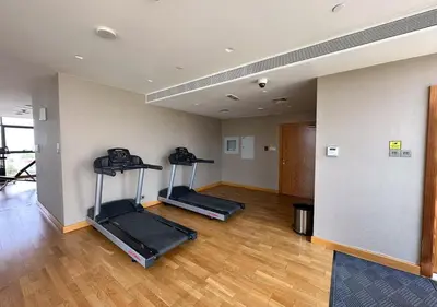 a gym with two treadmills in a room at Serene 1 BR in Damac Hills - Host & Stay in Dubai