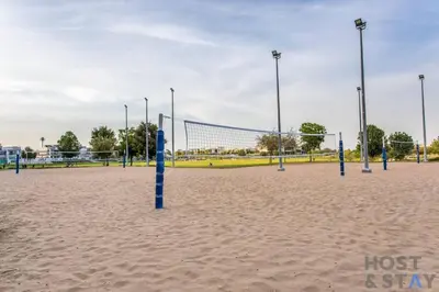 a volleyball court with blue posts in the sand at Lively 1 BR in Damac Hills, Dubai - Host & Stay in Dubai