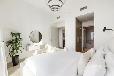 a white bedroom with a large white bed and a mirror at Panoramic Sea View 2BR in Forte Downtown - Allsopp&Allsopp in Dubai