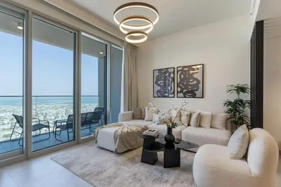 a living room with a couch and chairs and windows at Panoramic Sea View 2BR in Forte Downtown - Allsopp&Allsopp in Dubai