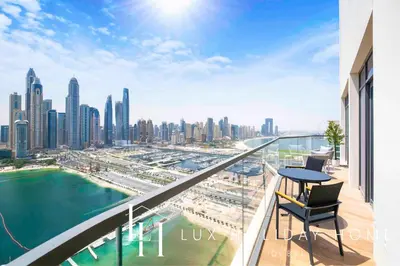 a balcony with a table and chairs and a city at LUX The Marina Vista Beachfront Suite 2 in Dubai