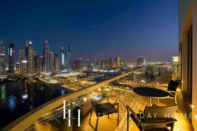 a view of a city skyline at night at LUX The Marina Vista Beachfront Suite 2 in Dubai