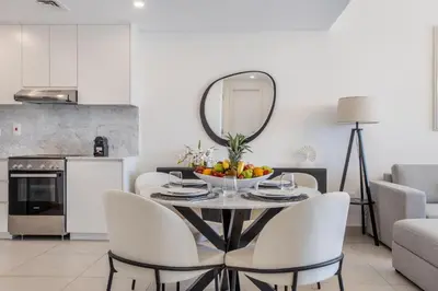 a dining room with a table with chairs and a mirror at One Bedroom Apartment in Madinat Jumeirah Living by The S Holiday Homes in Dubai