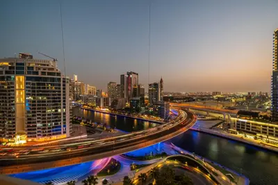 a city at night with a river and buildings at Family Sky Retreat at Address Beach on 56th Floor in Dubai