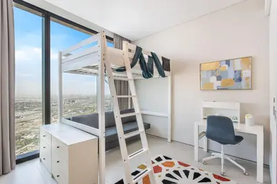 a bunk bed in a room with a desk and a chair at Family Sky Retreat at Address Beach on 56th Floor in Dubai