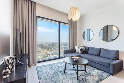 a living room with a blue couch and a large window at Family Sky Retreat at Address Beach on 56th Floor in Dubai