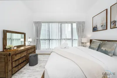 a bedroom with a large bed and a large window at Charming 1BR in The Point Tower, Dubai Marina by Deluxe Holiday Homes in Dubai