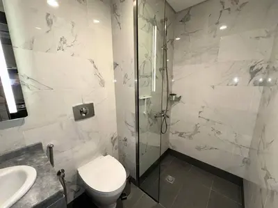 a bathroom with a shower and a toilet and a sink at Mag 510: 2-Bedroom Elegance in Dubai
