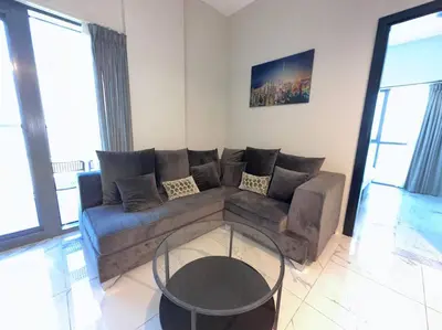 a living room with a couch and a glass table at Mag 510: 2-Bedroom Elegance in Dubai
