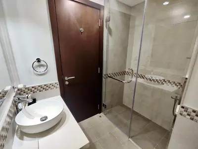 a bathroom with a shower and a toilet and a sink at Lux BnB I Vera Residences I Burj Views in Dubai