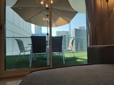a bedroom with a table and chairs and an umbrella at Lux BnB I Vera Residences I Burj Views in Dubai