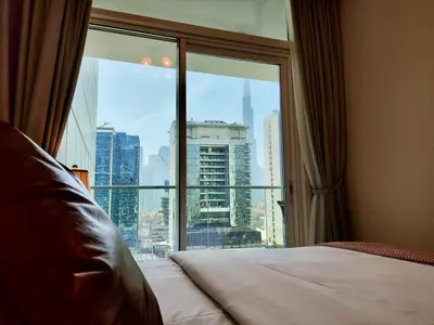 a bedroom with a large window with a view of a city at Lux BnB I Vera Residences I Burj Views in Dubai