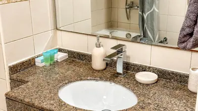 a bathroom counter with a sink and a mirror at Wonderful 1BR Apt with Marina view in Dubai
