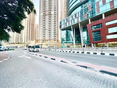 a bus driving down a city street with tall buildings at Wonderful 1BR Apt with Marina view in Dubai