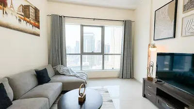 a living room with a couch and a tv at Wonderful 1BR Apt with Marina view in Dubai