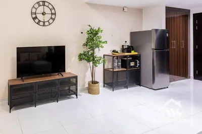 a living room with a television and a refrigerator at The Urban Oasis - Harmony in Dubai