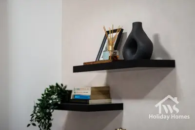 a shelf on the wall with a vase and books at The Urban Oasis - Harmony in Dubai