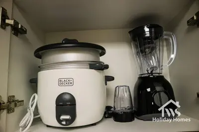 a slow cooker sitting on a counter next to a blender at The Urban Oasis - Harmony in Dubai
