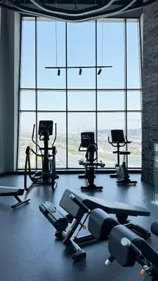 an empty gym with several tread machines in front of a large window at Exclusive Canal Waterfront Views 15 Northside in Dubai