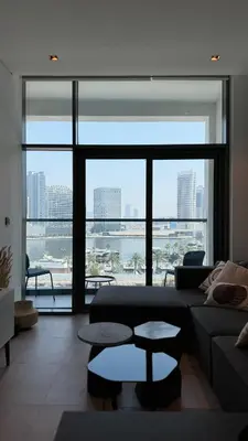 a living room with a couch and a large window at Exclusive Canal Waterfront Views 15 Northside in Dubai