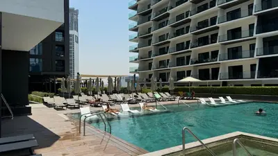 a swimming pool with chairs and people in a hotel at Exclusive Canal Waterfront Views 15 Northside in Dubai