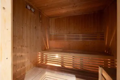 a sauna with wooden walls and a wooden floor at Large 1BR in JVC Sleeps 4 Rooftop, Pool & Gym in Dubai