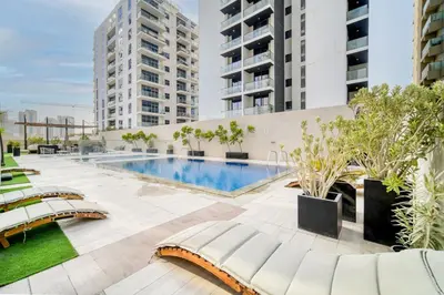 an apartment with a swimming pool and two buildings at Stella Stays Lana Tower in Dubai