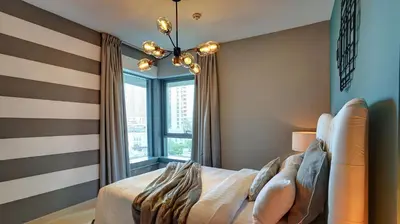 a bedroom with a bed and a large window at 29Boulevard - Modern 2BHK by Radiance Vacation Stays in Dubai
