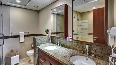 a bathroom with a sink and a toilet and a mirror at 29Boulevard - Modern 2BHK by Radiance Vacation Stays in Dubai