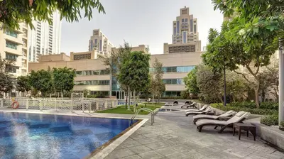 a hotel with a swimming pool in front of a building at 29Boulevard - Modern 2BHK by Radiance Vacation Stays in Dubai