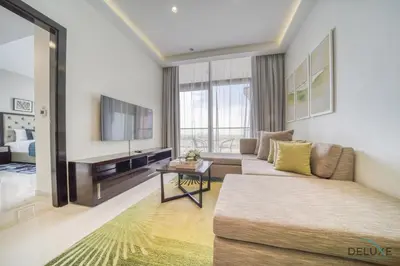 a living room with a couch and a tv at Urban 1BR at DAMAC Celestia B Dubai South by Deluxe Holiday Homes in Dubai