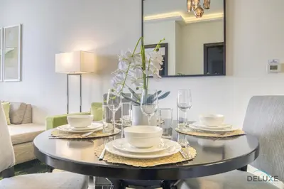 a dining room table with plates and dishes on it at Urban 1BR at DAMAC Celestia B Dubai South by Deluxe Holiday Homes in Dubai