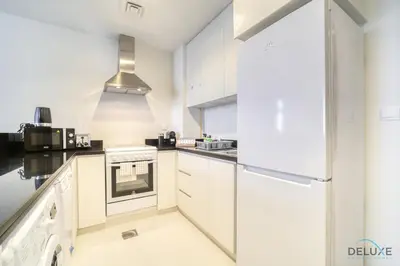 a kitchen with white cabinets and a stove at Urban 1BR at DAMAC Celestia B Dubai South by Deluxe Holiday Homes in Dubai